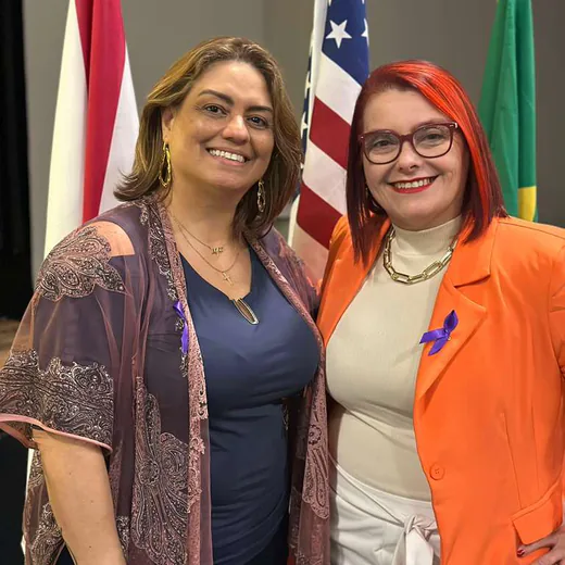 Two members of the team in front of the flags