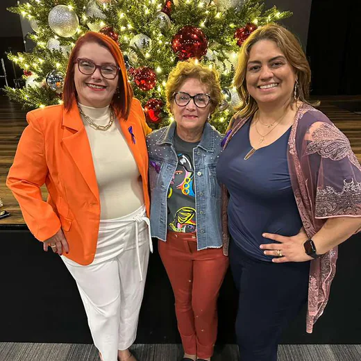 Three guests in front of the Christmas tree on stage