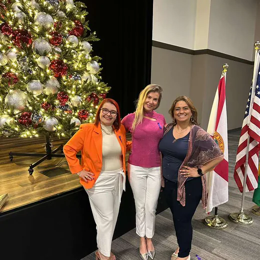 Three guests between the Christmas tree and the flags
