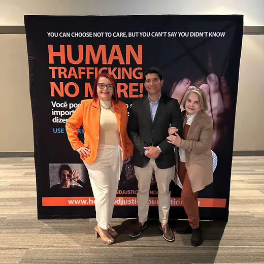 Three guests in front of the “Human trafficking no more” panel