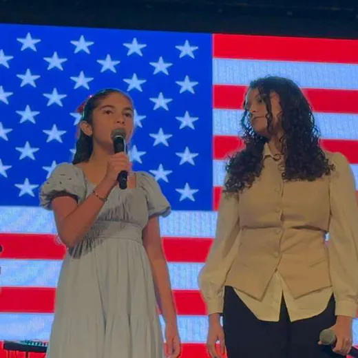 The national anthem on stage, with the U.S. flag on the screen
