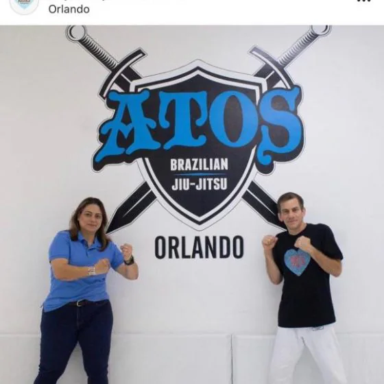 Two participants in a guard stance under the academy logo