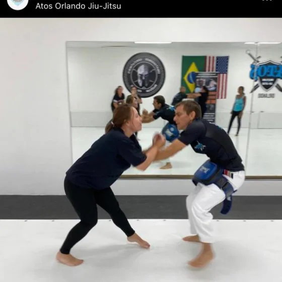 Two participants practising a self-defence hold on the mat